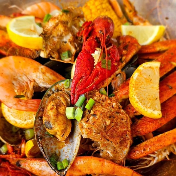Close-up of My Brother's Crawfish seafood boil with crawfish, shrimp, mussels, corn, and lemon.